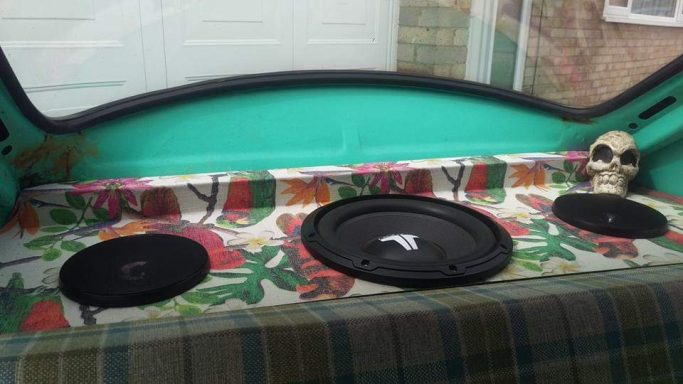 A decorative car interior featuring three speakers and a skull.