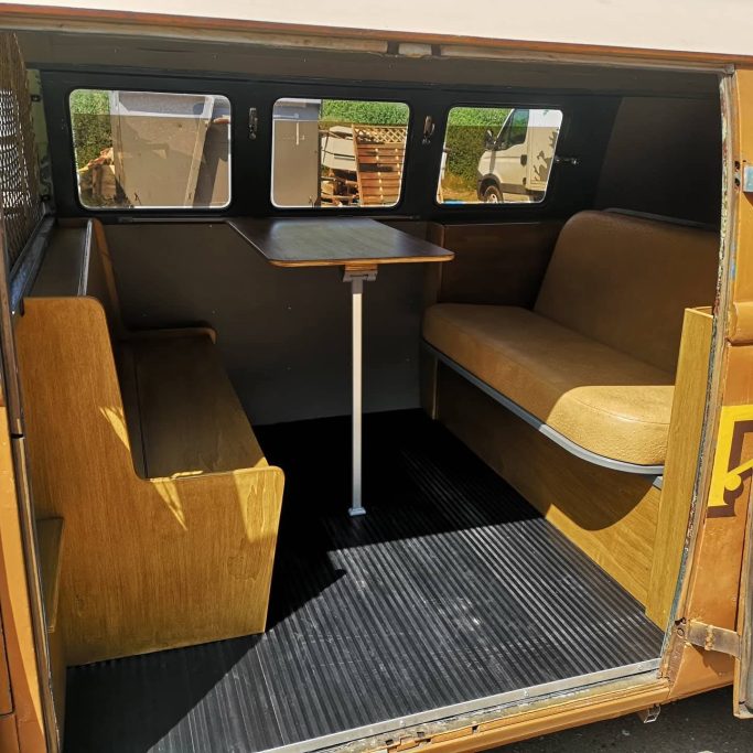 Interior view of a compact seating area with two benches and a table.